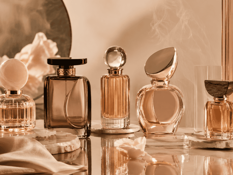 Elegant collection of luxury perfume bottles with warm lighting and soft background.